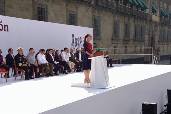 Primer plano de Claudia Sheinbaum en el podio, gesticulando mientras anuncia el Sistema de Salud Universal.