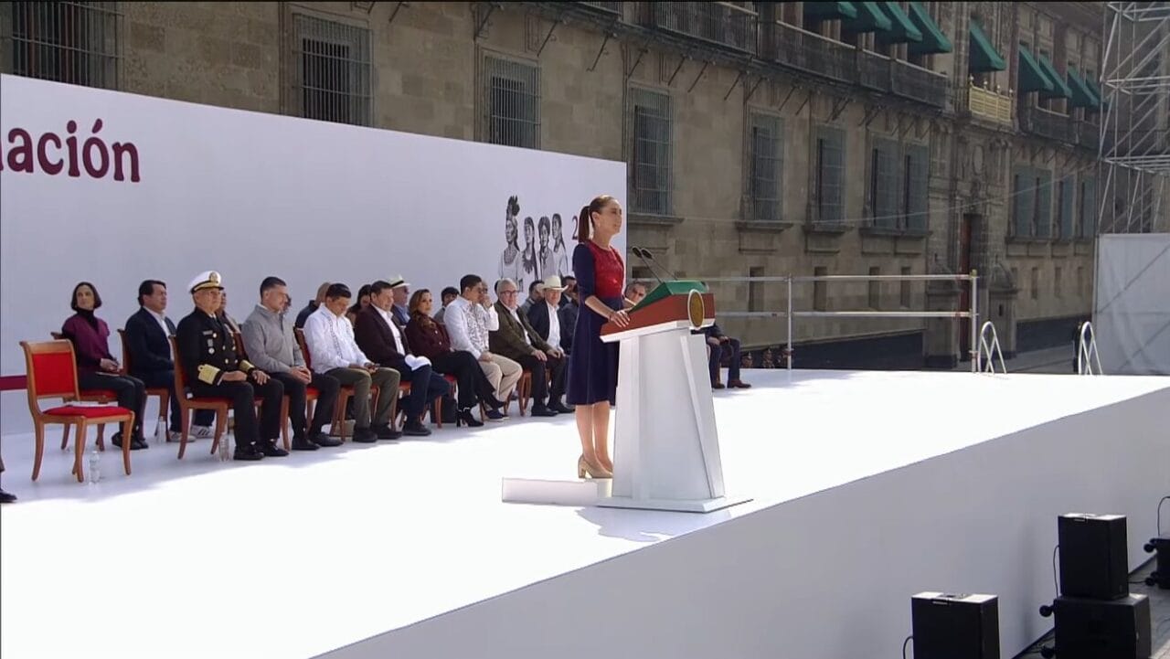 Primer plano de Claudia Sheinbaum en el podio, gesticulando mientras anuncia el Sistema de Salud Universal.