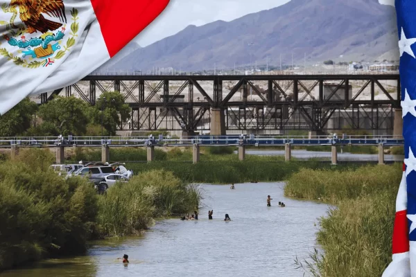 Migrantes cruzando el Río Bravo con banderas de México y Estados Unidos en la frontera, reflejando crisis humanitaria.